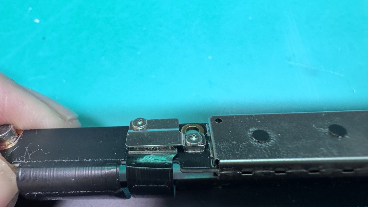 Close-up of a MacBook Pro display flex cable at the hinge point where it bends and eventually tears