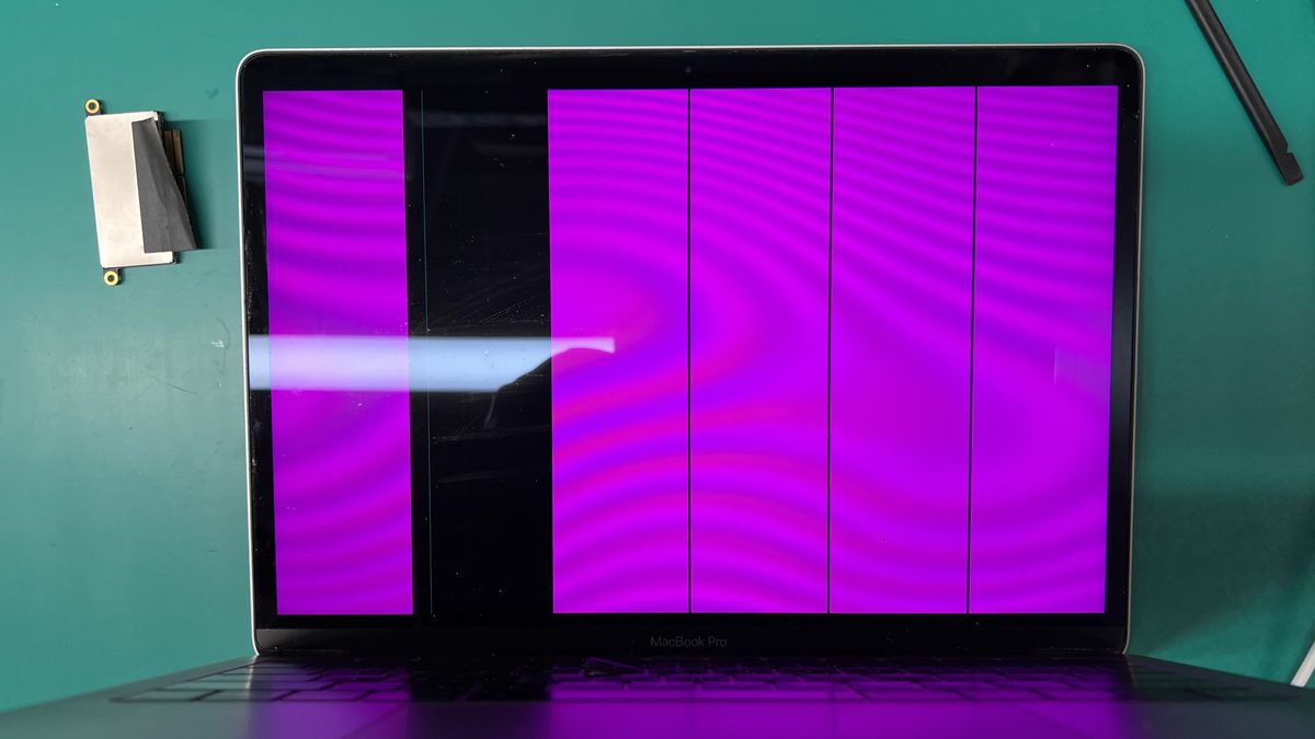 MacBook Pro display showing stage lighting effect with bright purple vertical bars caused by damaged flex cable