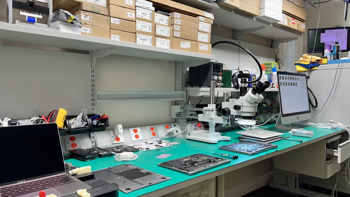 WarriorMac repair bench with multiple MacBook and iMac displays laid out for screen repair and diagnostics