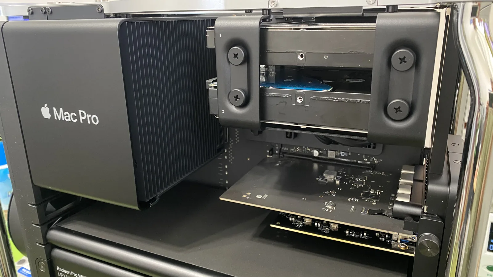 A Mac Pro being serviced at WarriorMac in Tampa, with an MPX graphics module partially removed to access the logic board