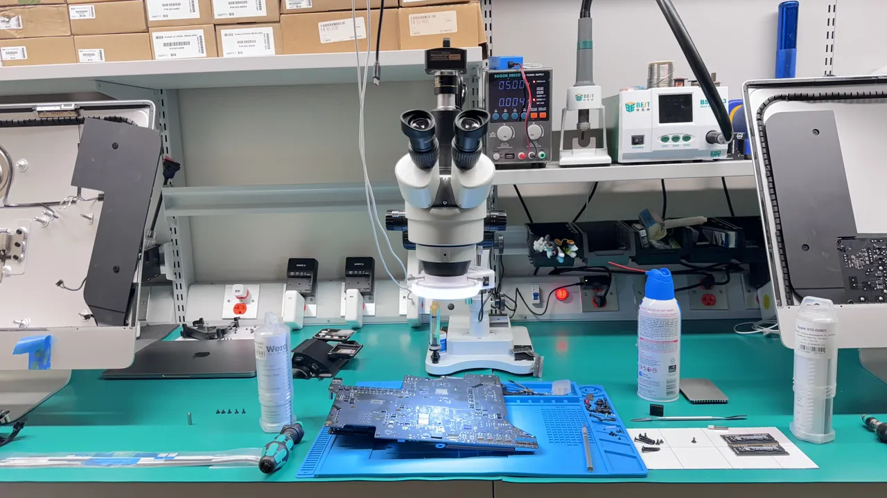 WarriorMac Tampa micro-soldering workstation with stereoscope microscope, power supply, and iMac logic board ready for component-level Apple Mac repair