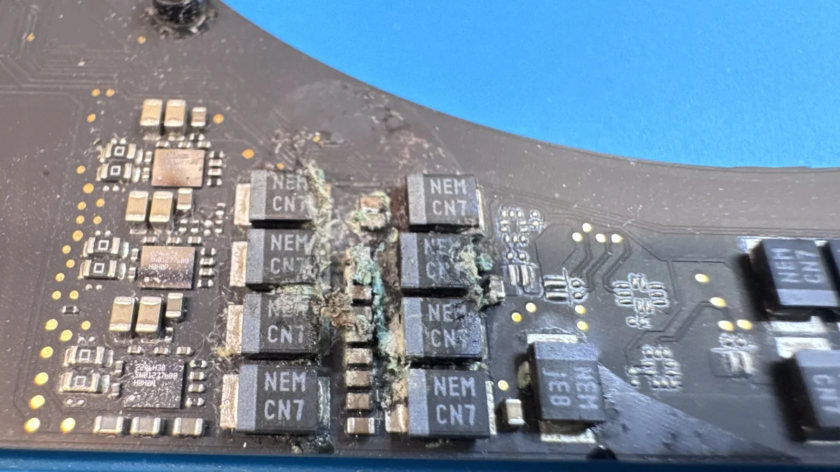 Close-up of corroded logic board components requiring micro-soldering repair