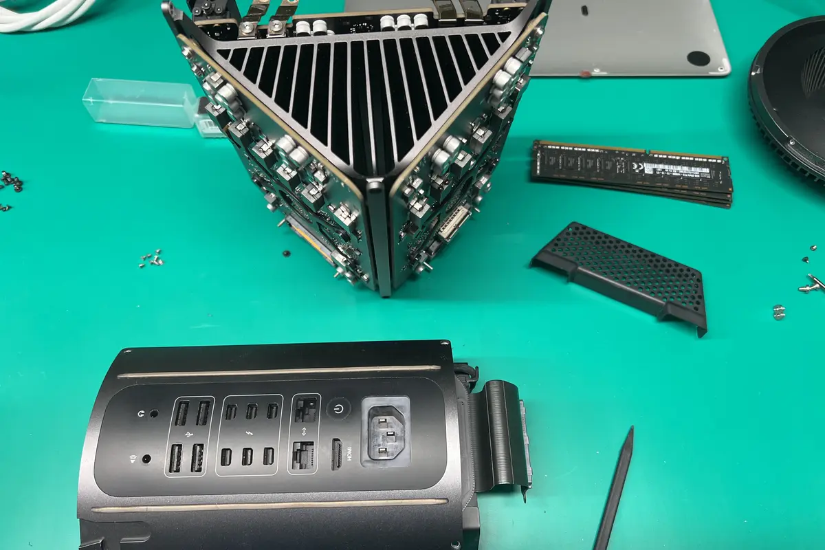 Mac Pro 2019 fully disassembled on green workbench showing internal frame, RAM, and I/O panel at WarriorMac Tampa
