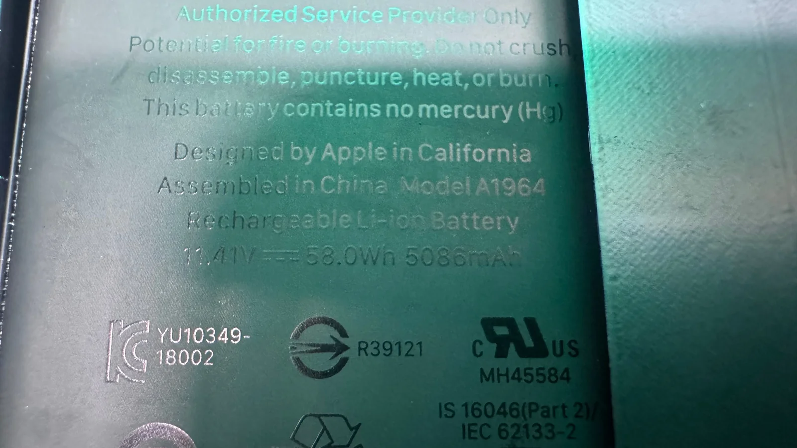 Close-up of Apple MacBook Pro battery label showing Model A196A 58.0Wh Li-ion specifications at WarriorMac Tampa