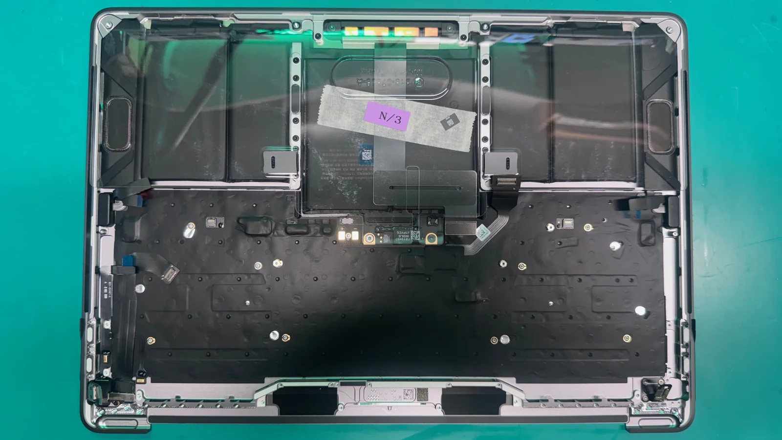 MacBook Pro with battery removed showing empty battery bay and exposed chassis at WarriorMac repair shop Tampa FL