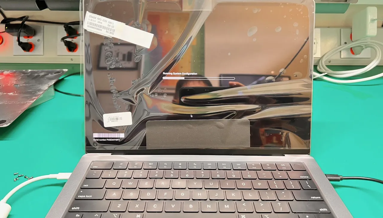 MacBook Pro screen replacement in progress at WarriorMac Tampa repair center running system configuration after genuine Apple display installation