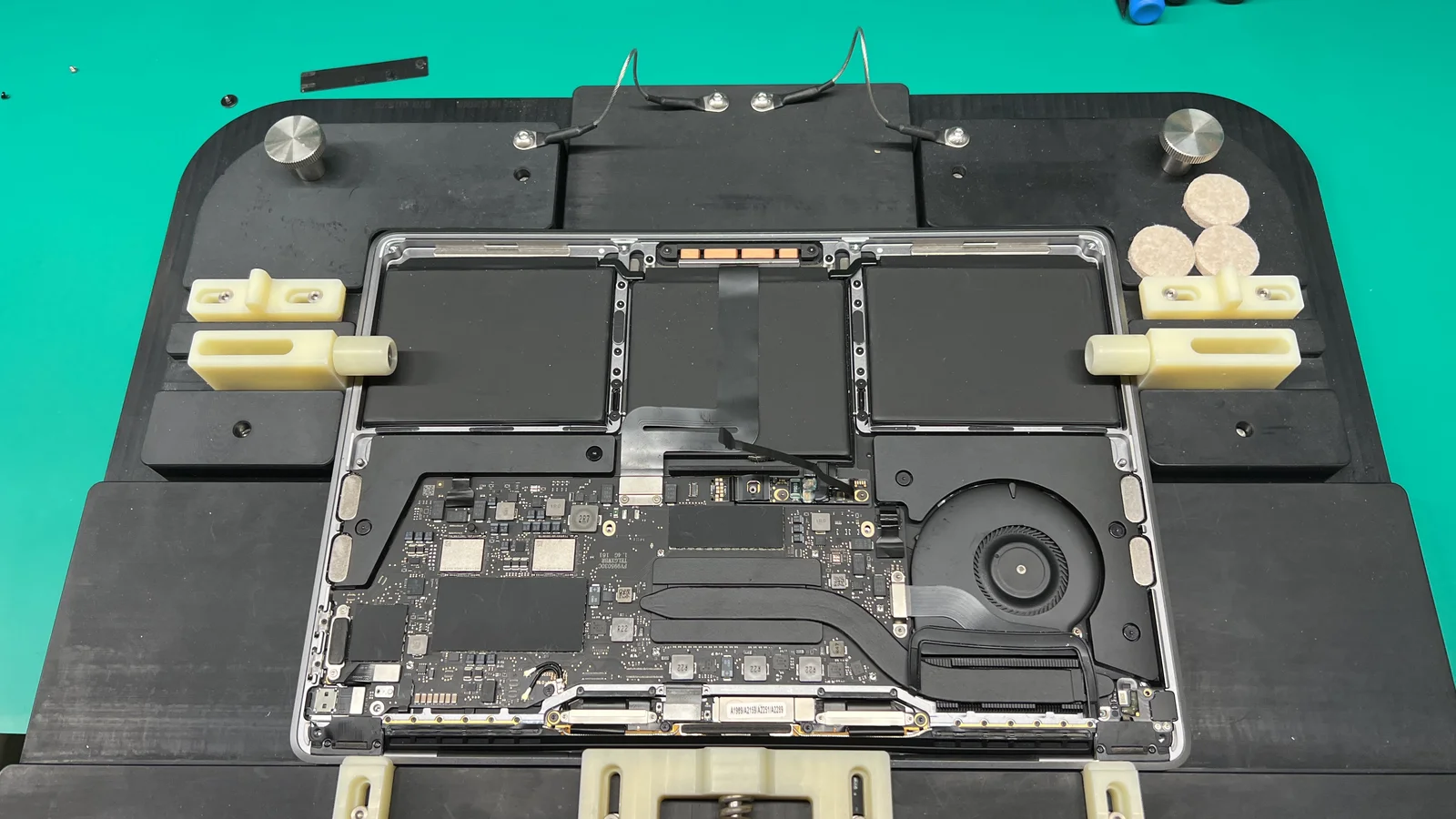 MacBook on professional repair jig with logic board and internals exposed at WarriorMac Tampa