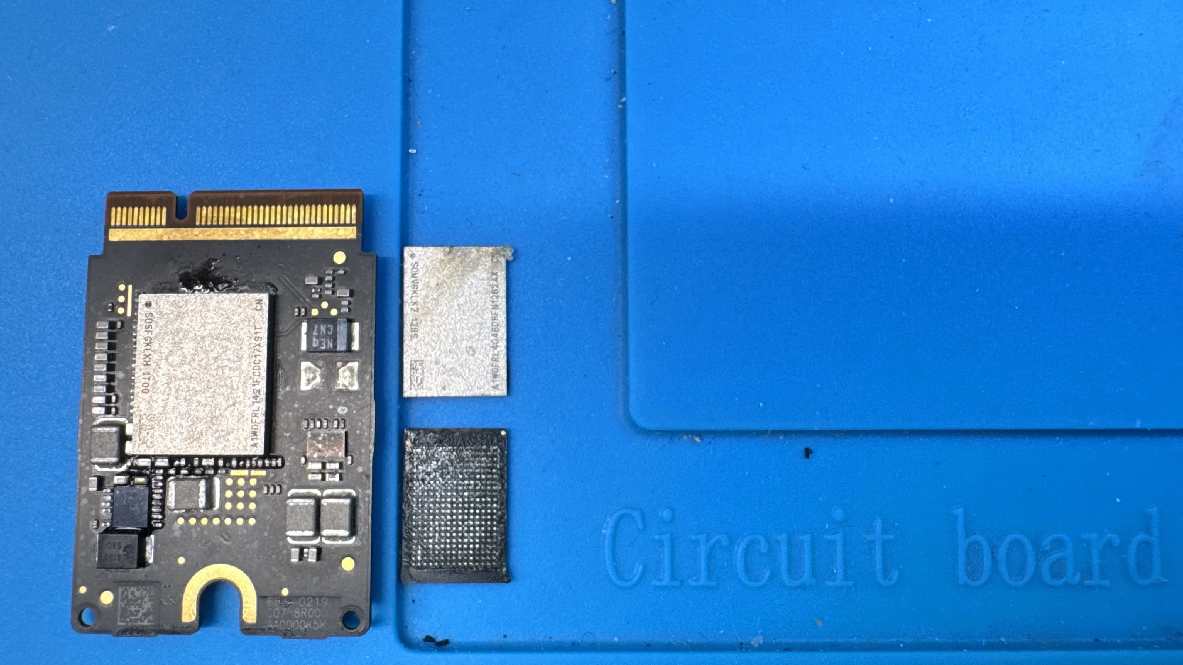 Mac SSD module with NAND flash chip on WarriorMac repair bench in Tampa showing board-level upgrade components