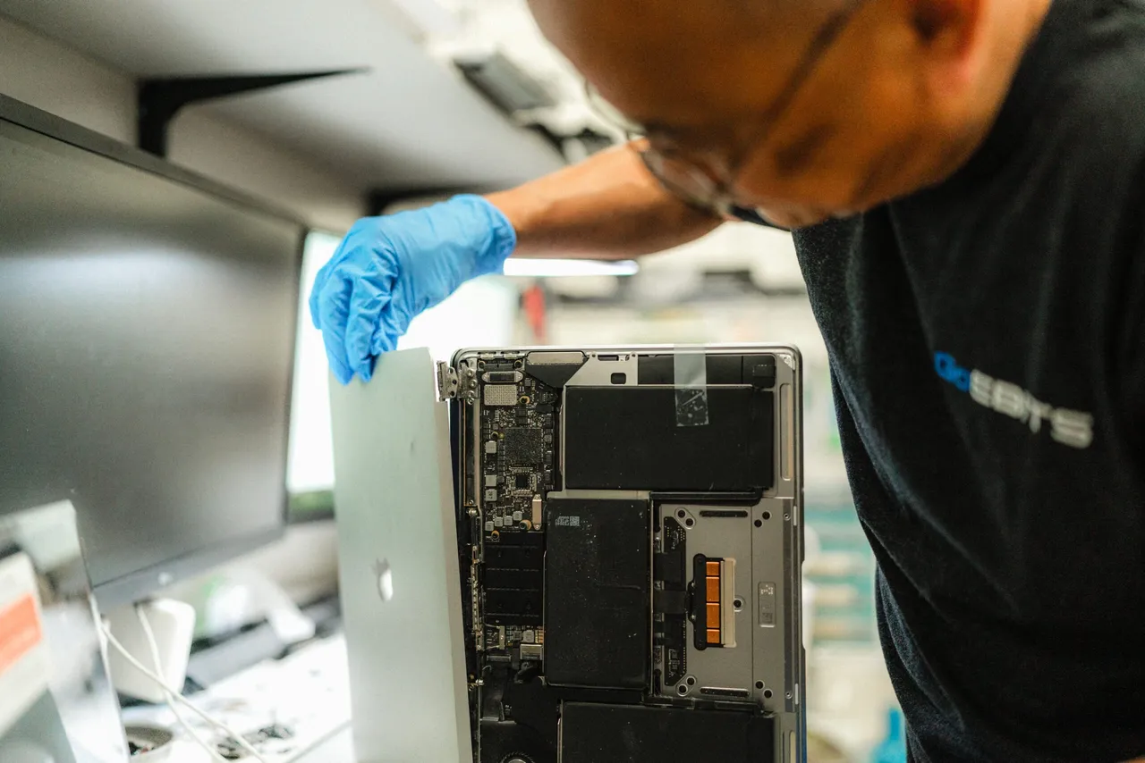 Technician diagnosing MacBook trackpad issue at WarriorMac